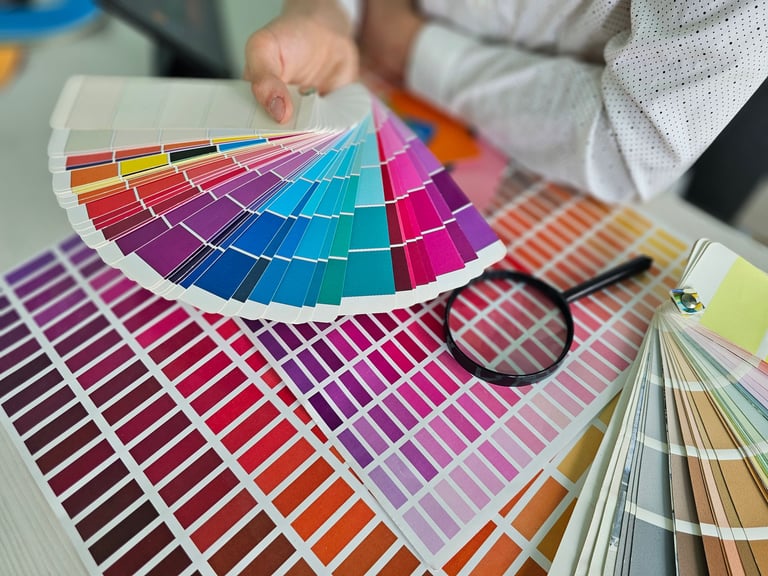 Choosing colors in a design studio while holding color swatches and examining options with a magnifying glass