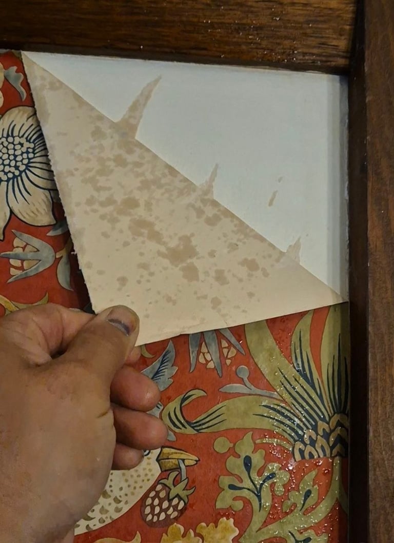 Hand folding decorative paper with floral patterns in a frame with wooden border